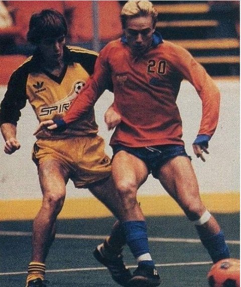 Spirit player in the gold home kit shielding the ball from a defender
